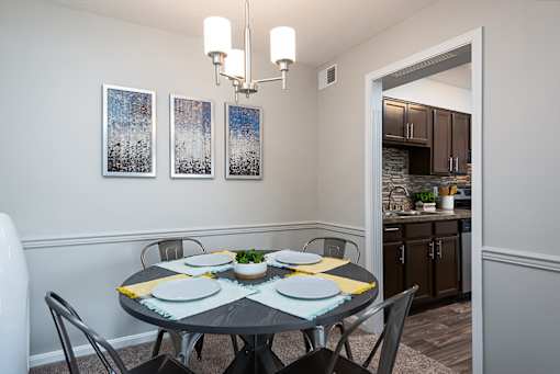 A dining room with a table set for four.
