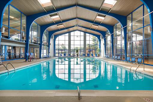 A large indoor swimming pool with a blue ceiling and walls.