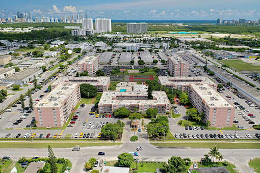A large parking lot is surrounded by buildings.