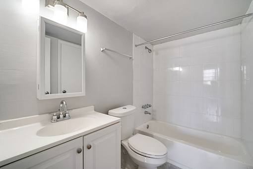A white bathroom with a sink, toilet, and bathtub.