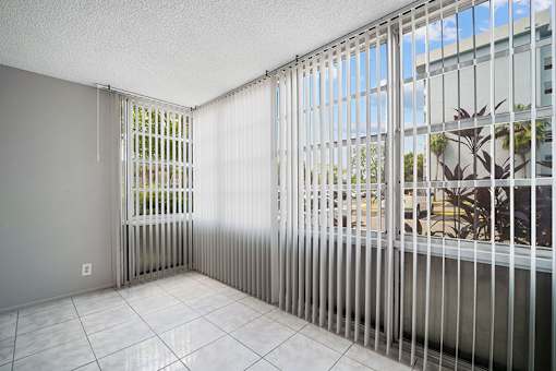 A room with a window covered by a metal grill.