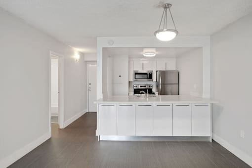 A kitchen with white cabinets and stainless steel appliances.