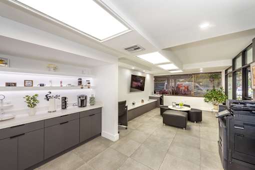 A modern kitchen with a skylight and a dining area.