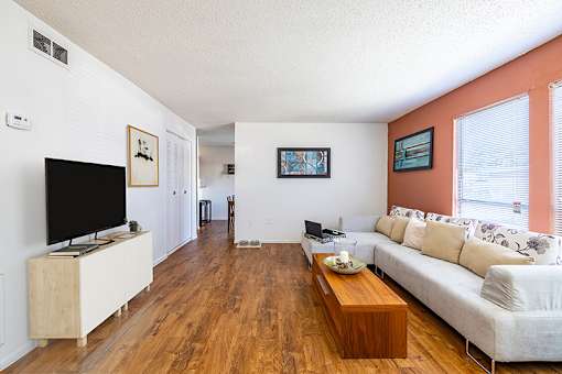 A living room with a white couch and a wooden coffee table.