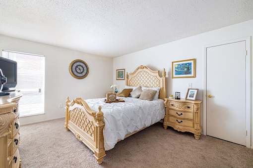A bedroom with a bed, dresser, and mirror.