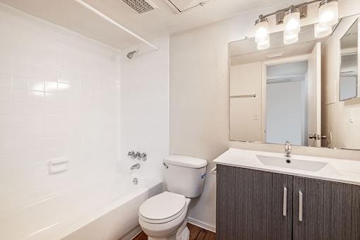A white toilet sits next to a bathtub in a bathroom.