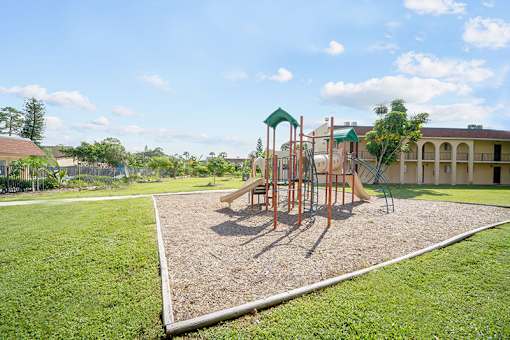 A playground with a swing set and a green canopy.