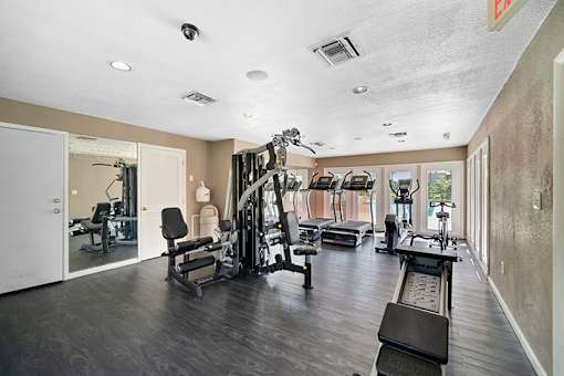 A spacious gym with a variety of equipment including treadmills, weights, and exercise machines.