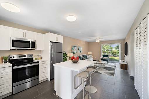 A kitchen with a white counter top and stainless steel appliances.