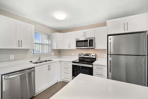 A kitchen with white cabinets and stainless steel appliances.
