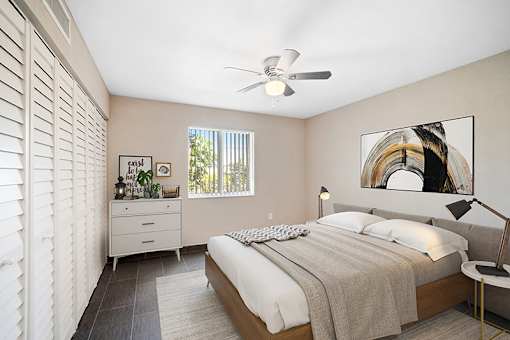 A bedroom with a bed, nightstand, and a painting on the wall.