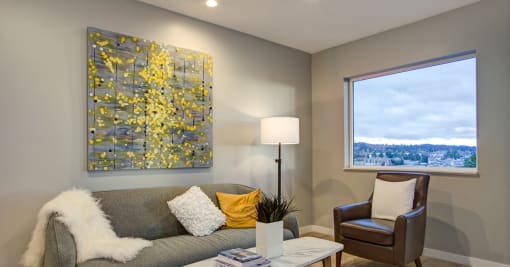 a living room with a large painting on the wall and a couch and chair in front of