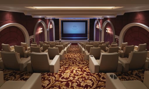 a large auditorium with rows of chairs and a large screen