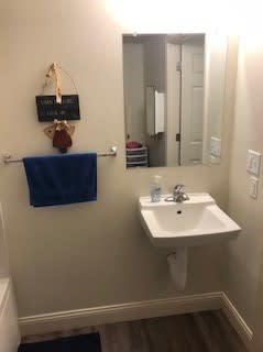 A bathroom with a white sink and a blue towel hanging on the wall.