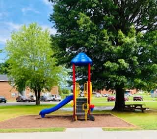 A playground with a blue slide and a red and yellow structure.