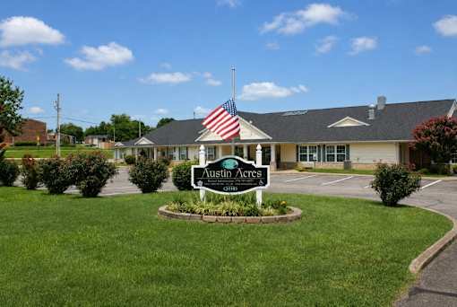 A sign in front of a building that says "Austin Acres".
