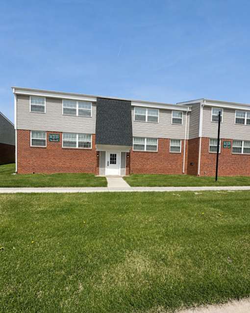 A building with a green lawn in front.