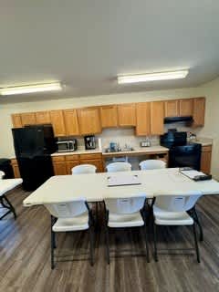 A kitchen with a table and chairs in front of it.