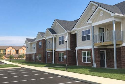 A row of townhouses with a parking lot in front.