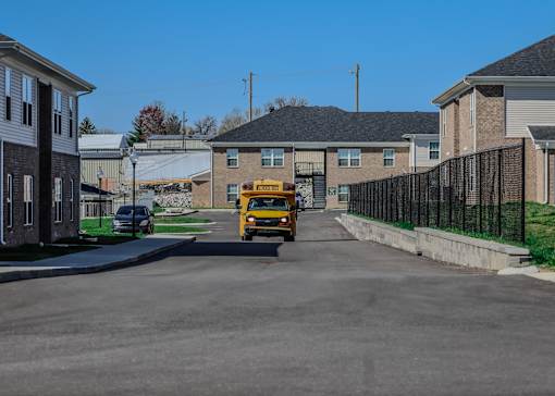 a school bus driving down a street in front of houses