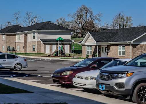 a group of cars parked in a parking lot in front of houses