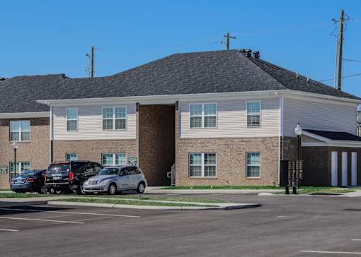 a large brick house with cars parked in front of it