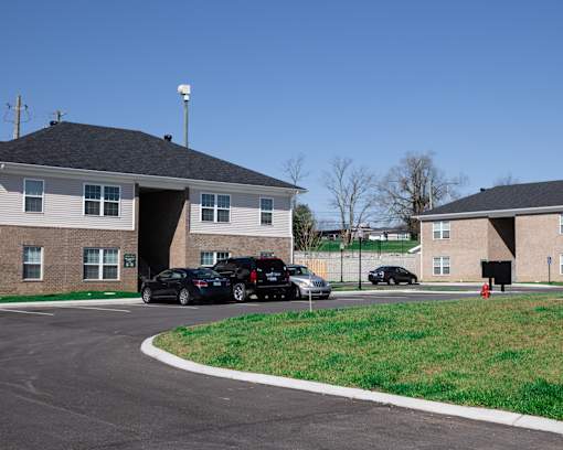 a parking lot in front of two buildings with cars parked