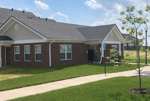 A small brick building with a white trim and a small porch.