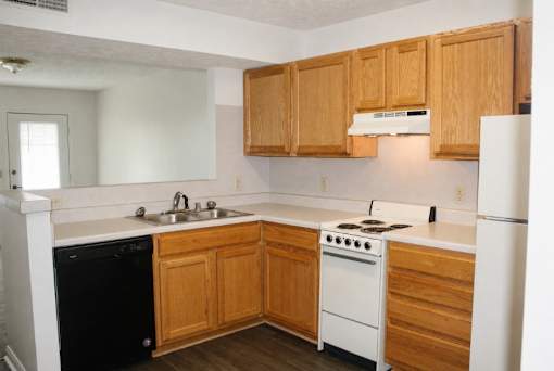 A kitchen with wooden cabinets and white appliances.