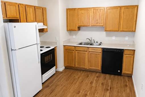 A kitchen with wooden cabinets and a white refrigerator.