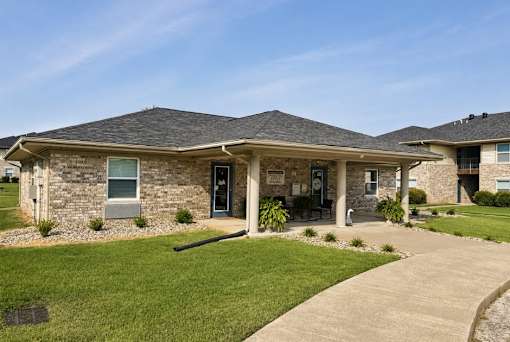 A house with a grey roof and a green lawn in front.