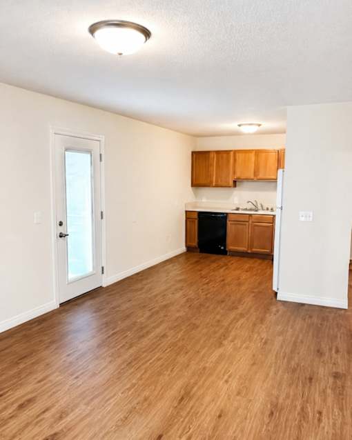A kitchen area with wooden floors and white walls.
