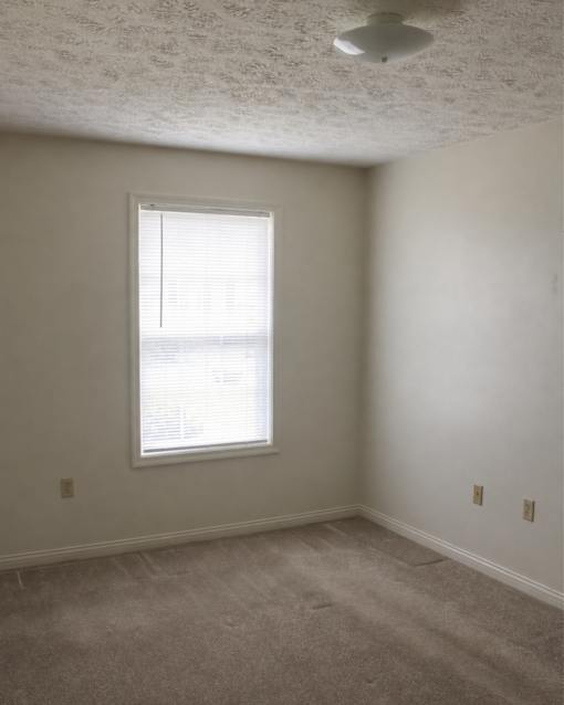 A room with a window and a ceiling fan.