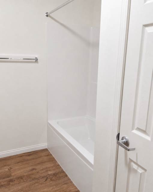 A white door with a silver handle is open.