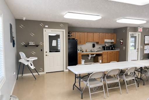 A kitchen with a table and chairs in the foreground.