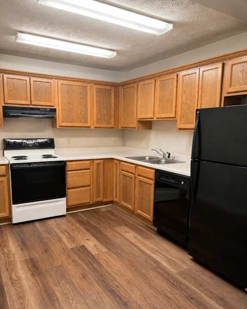 A kitchen with wooden cabinets and black appliances.