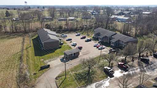 A parking lot with cars and a building in the background.
