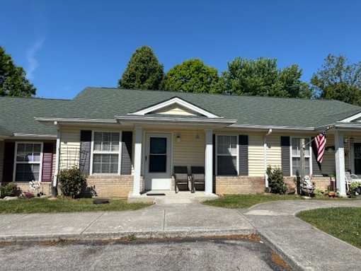 A house with a grey roof and a grey front porch.