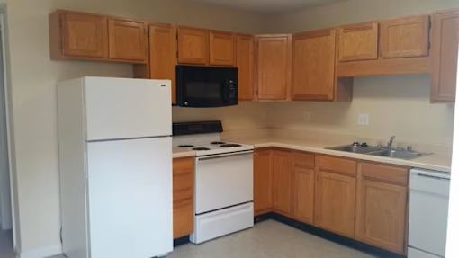 A kitchen with wooden cabinets and white appliances.