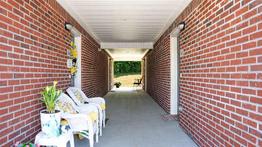 A white chair is on the porch.