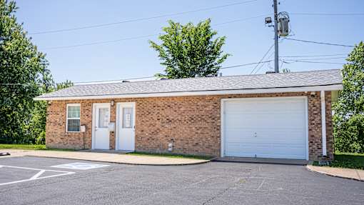 A small brick building with a white garage door.