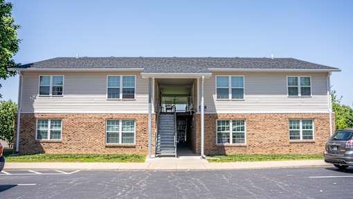 A two-story building with a brick facade and a grey roof.