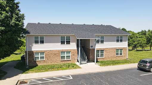 A two-story building with a parking lot in front.