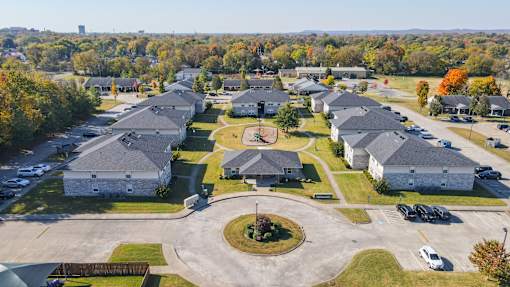 A large group of houses are surrounded by a parking lot.