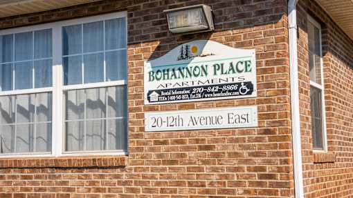 A sign on a brick building that says Bohannon Place Apartments.
