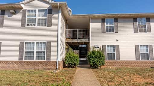 A two-story apartment building with a balcony on the second floor.