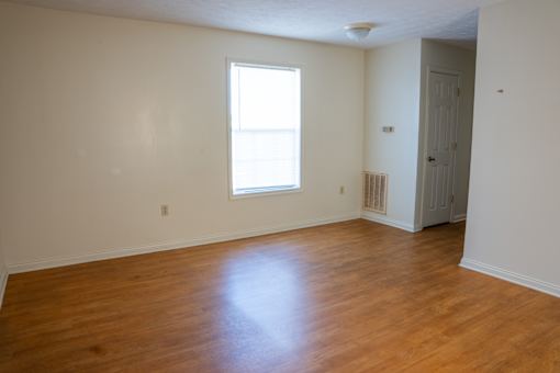 A room with a wooden floor and a window.