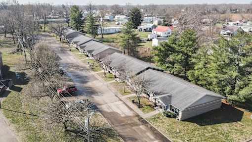 A long row of buildings with a red car parked in the distance.