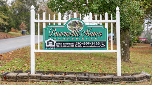 A sign for Brownsville Manor Apartments with rental information.