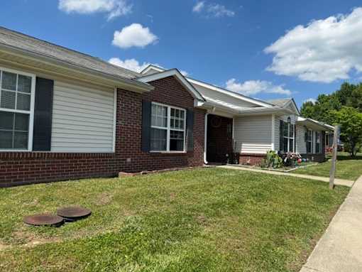 A house with a red brick wall and a white siding.